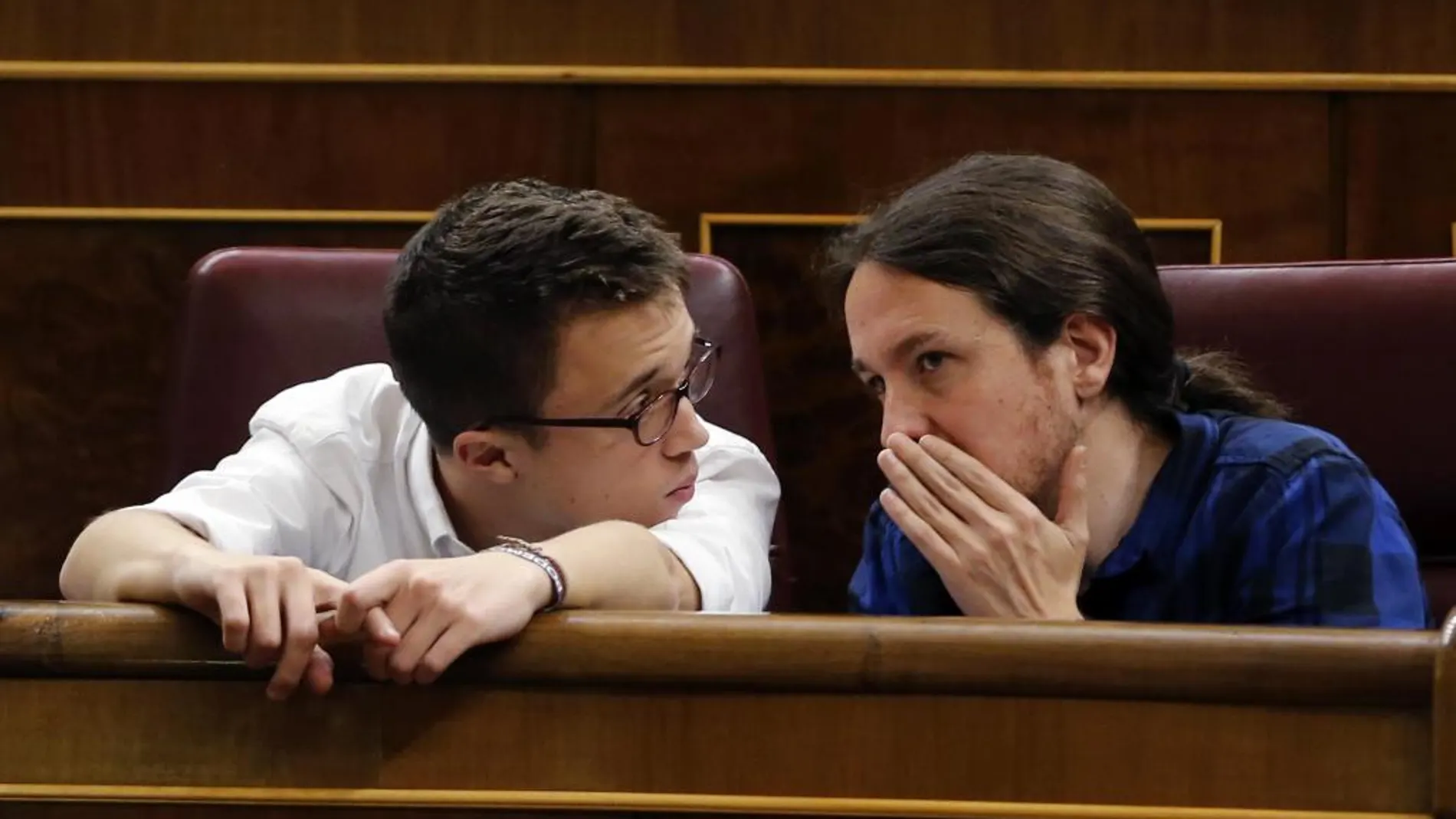 El líder de Podemos, Pablo Iglesias (d), conversa con el portavoz parlamentario, Íñigo Errejón (i)
