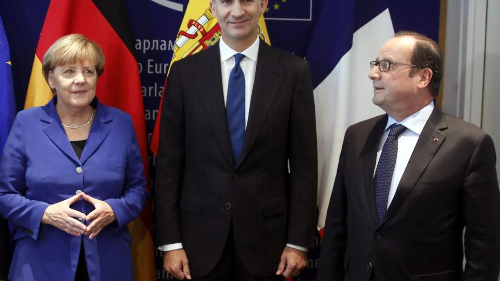 El Rey Felipe, que intervino hoy por vez primera ante el pleno del Parlamento Europeo, reunido en sesión solemne en Estrasburgo, posa junto a la canciller alemana, Angela Merkel y el presidente de Francia, François Hollande (d), con quienes mantuvo una reunión.