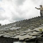 Daniel, natural de Majaelrayo, en Guadalajara, repara el tejado de su casa la cual forma parte de la arquitectura negra de la zona, realizada a base de pizarra