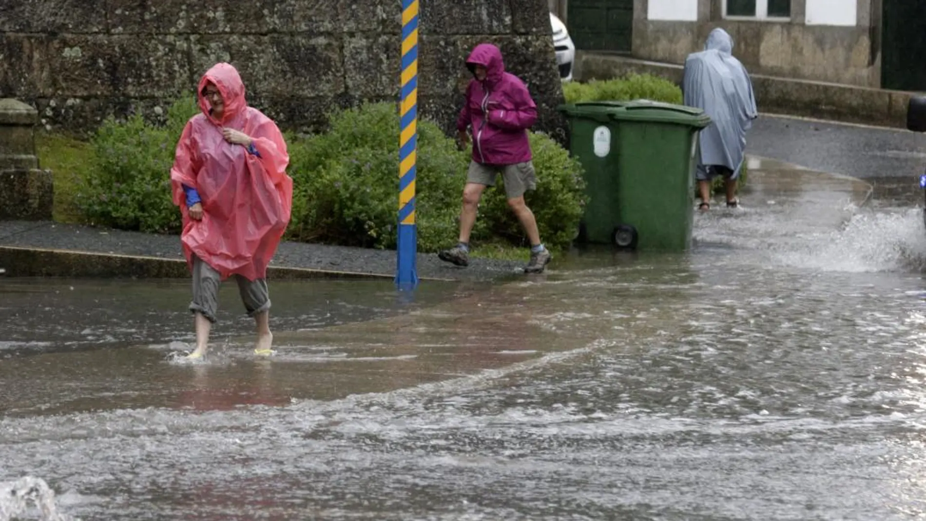 Varios peregrinos en una calle inundada en Santiago de Compostela el pasado lunes