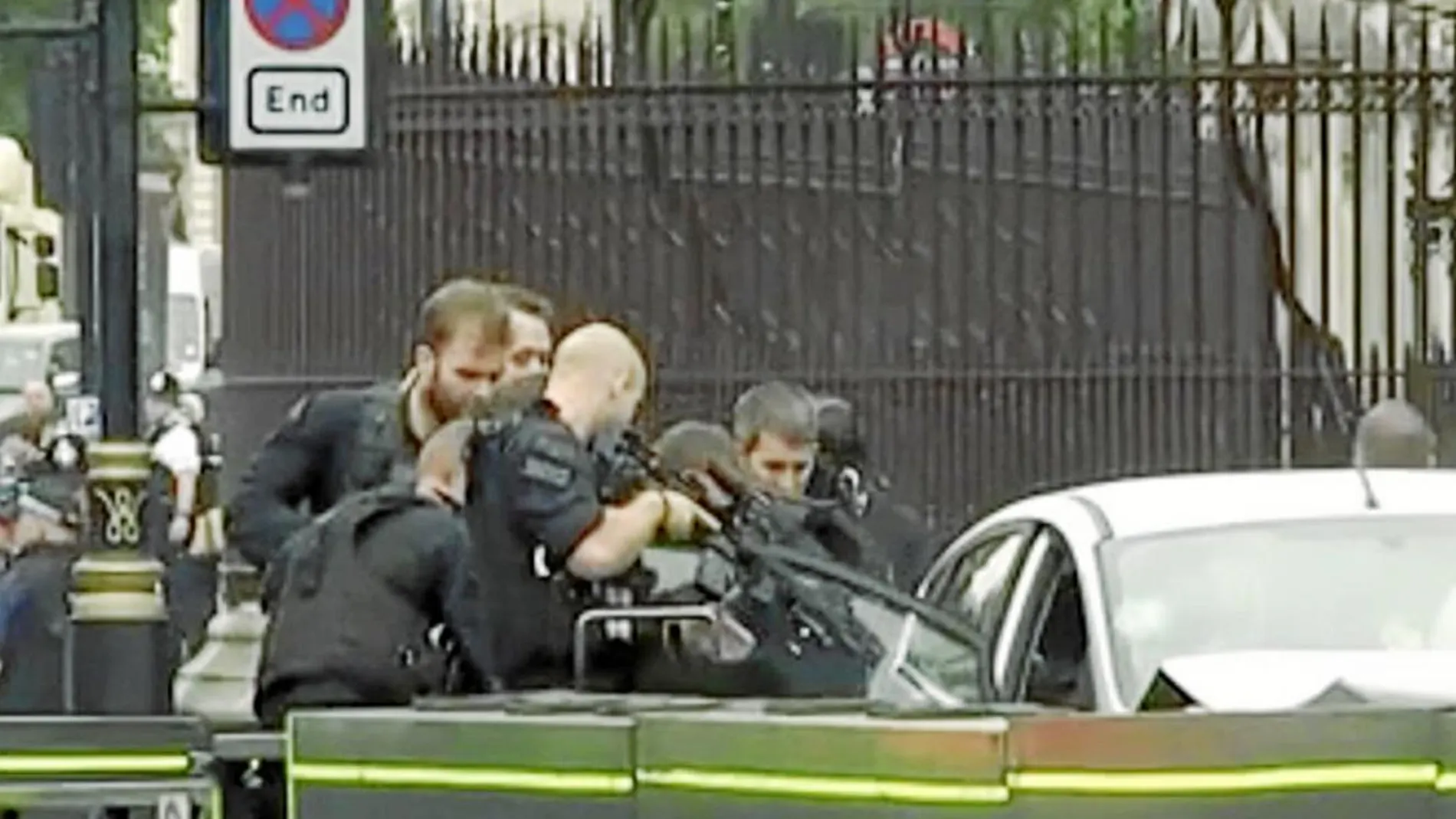 Agentes de la Policía Metropolitana de Londres apuntan con sus armas al conductor tras estrellarse ayer por la mañana contra la barrera de seguridad del Parlamento británico