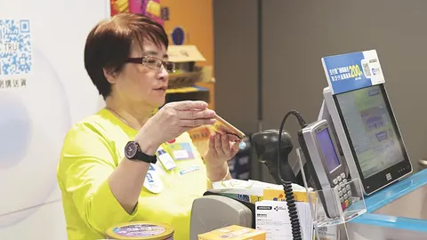 Una comerciante china, en el momento de leer un código QR