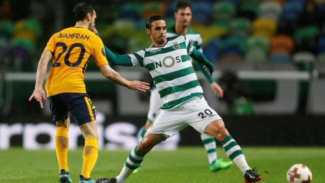 Bryan Ruiz del Sporting de Lisboa pelea un balón junto a Juanfran del Atlético