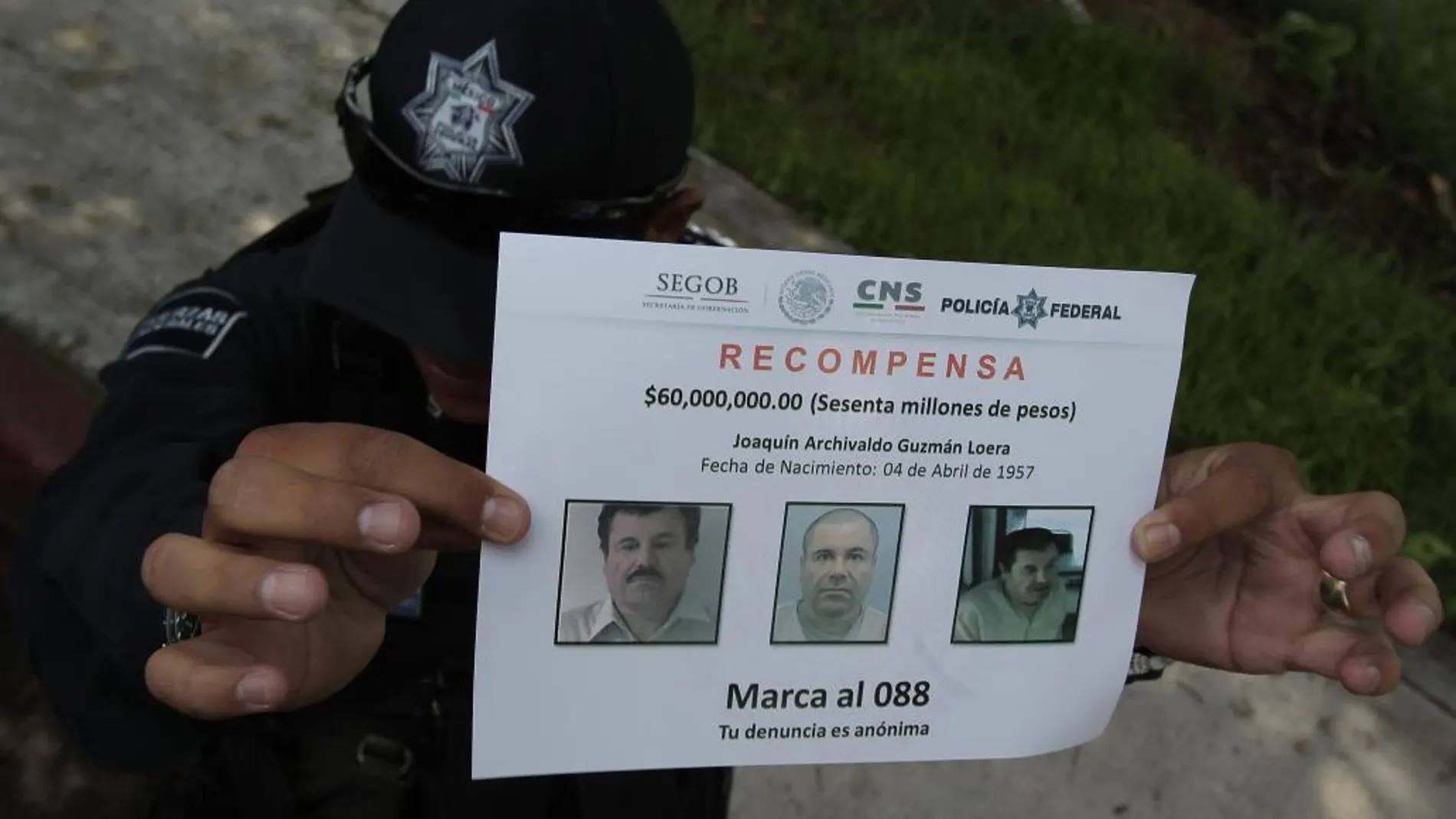 Un policía muestra un aviso de recompensa
