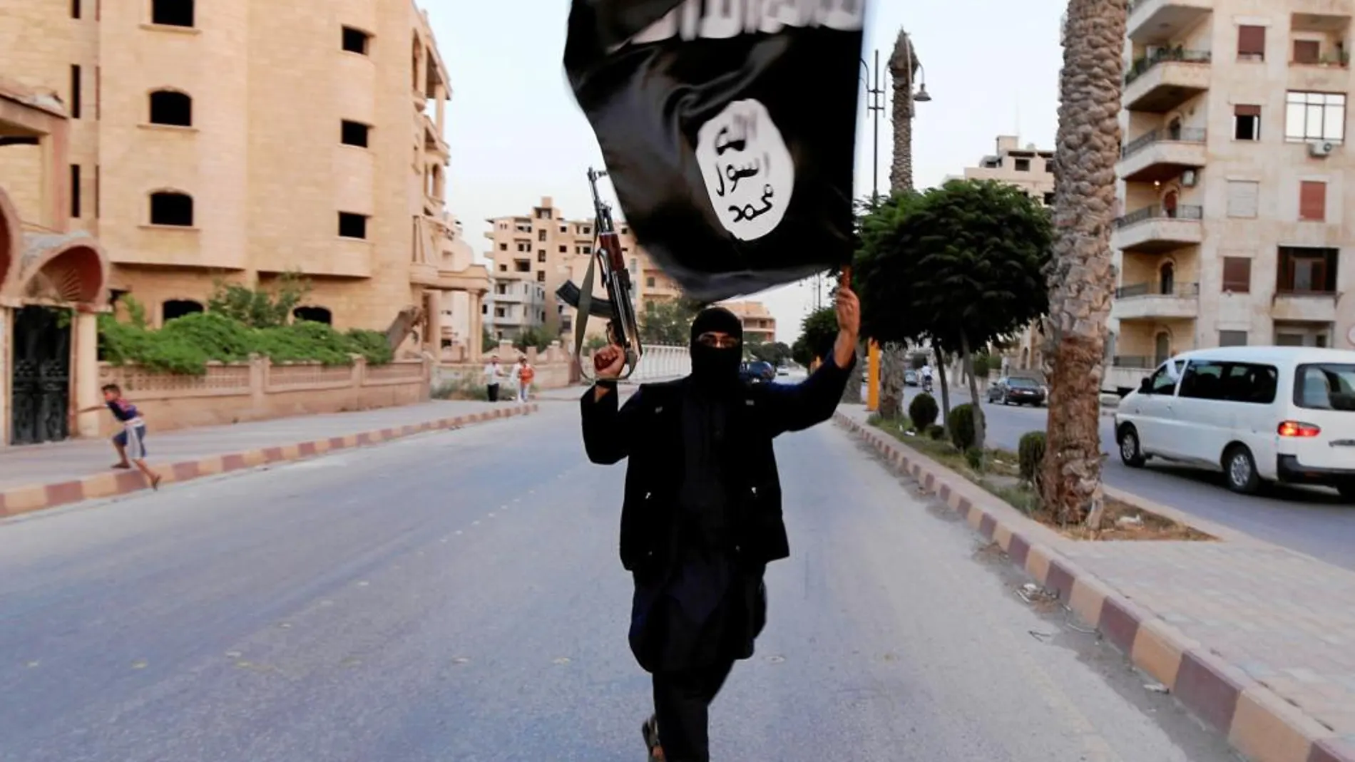 Un miembro del Estado Islámico, con la bandera del grupo terrorista