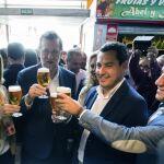 El presidente del Gobierno en funciones, Mariano Rajoy (c), el presidente del PP andaluz, Juanma Moreno (2d), la ministra de Empleo y Seguridad Social en funciones, Fátima Báñez (i) brindan con unas cañas de cerveza en el Mercado de Atarazana, durante el recorrido por el centro de Málaga.