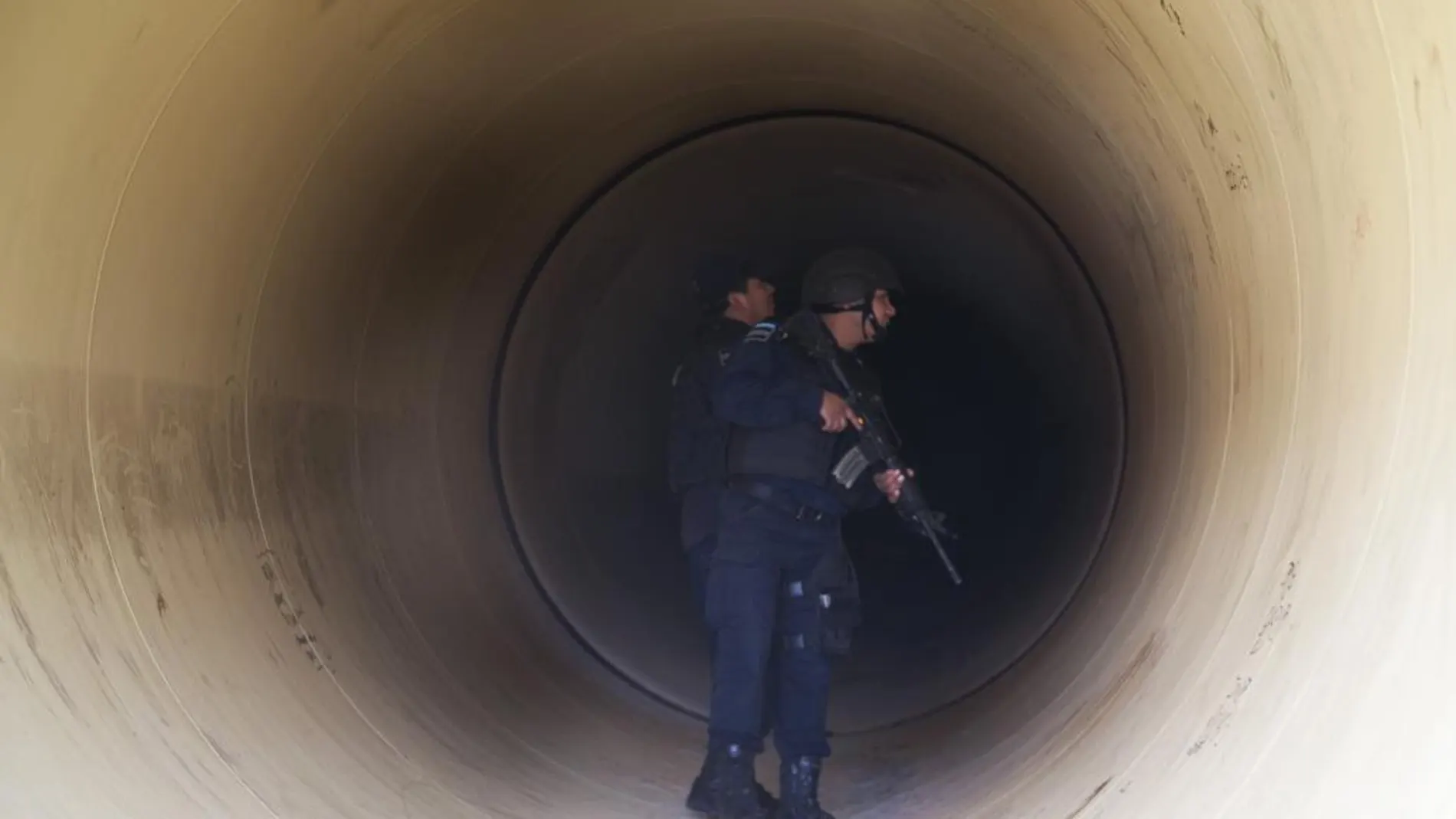 La policía federal inspecciones una tubería por la que se escapó el "Chapo"Guzmán.