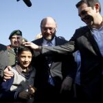El primer ministro griego, Alexis Tsipras, y el presidente del Parlamento Europeo, Martin Schulz saludan a un niño refugiado.