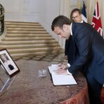 Emmanuel Macron firma un libro de condolencias en memoria de las víctimas del atentado de Manchester junto al embajador inglés en Francia, Edward Llewellyn.