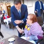 El presidente del Gobierno en funciones, Mariano Rajoy, saluda a una vecina de Burgos en su último vídeo electoral