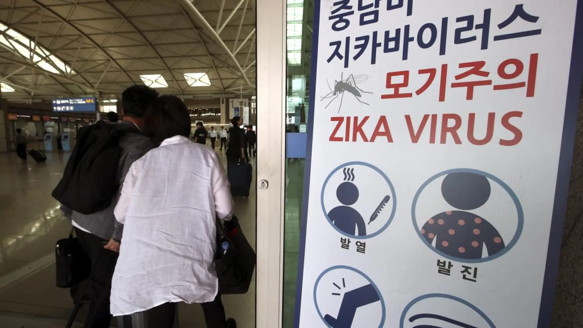 Un cartel avisa a los viajeros de los síntomas del virus del Zika en la terminal de salidas del aeropuerto de Incheon, al oeste de Seúl (Corea del Sur)