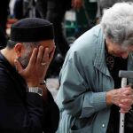 Un mujer judía y un hombre musulmán lloran junto al tributo a las víctimas del Manchester Arena.