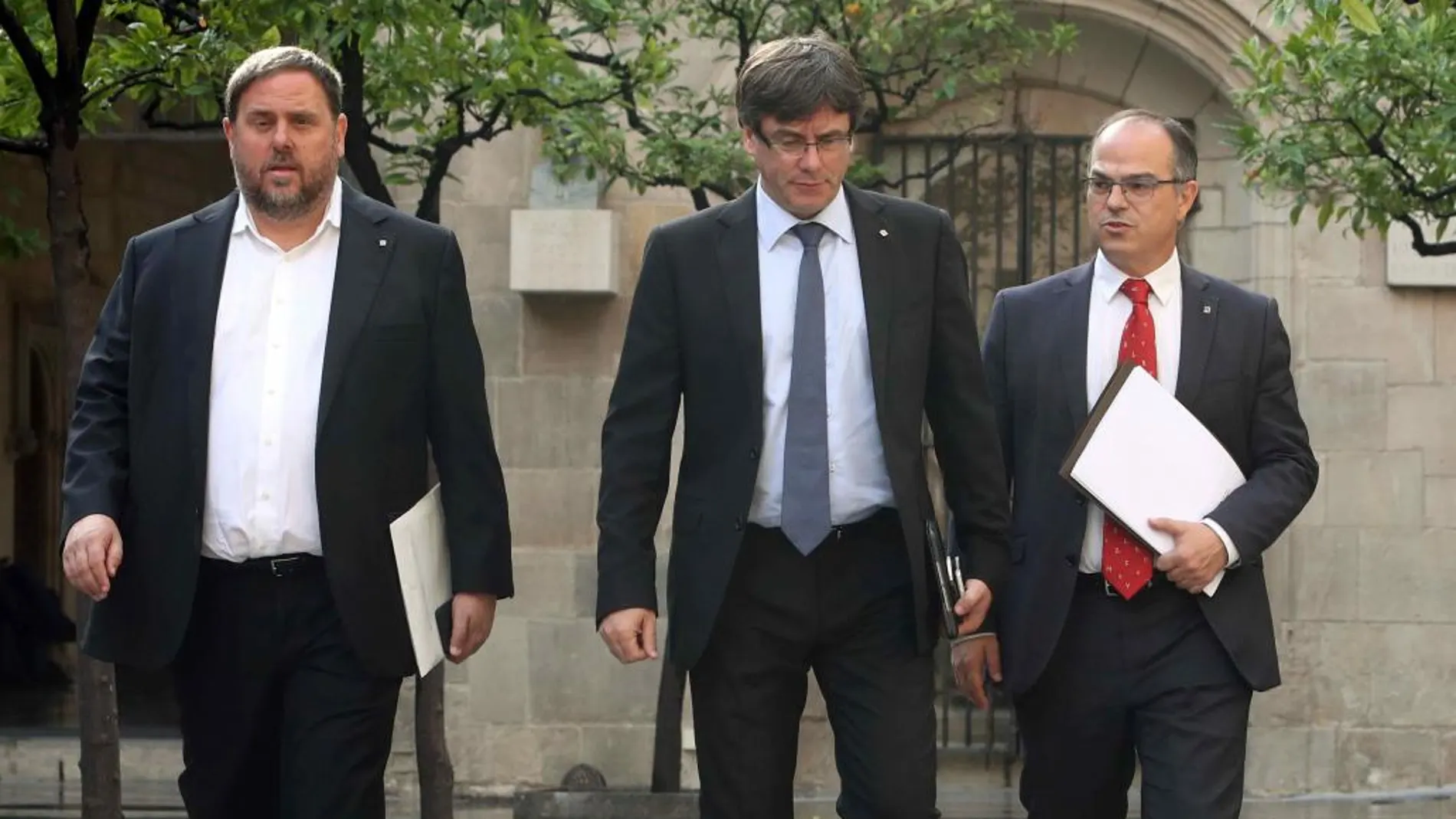 El presidente de la Generalitat, Carles Puigdemont (c), junto al vicepresidente, Oriol Junqueras (i), y el conseller de Presidencia, Jordi Turull.