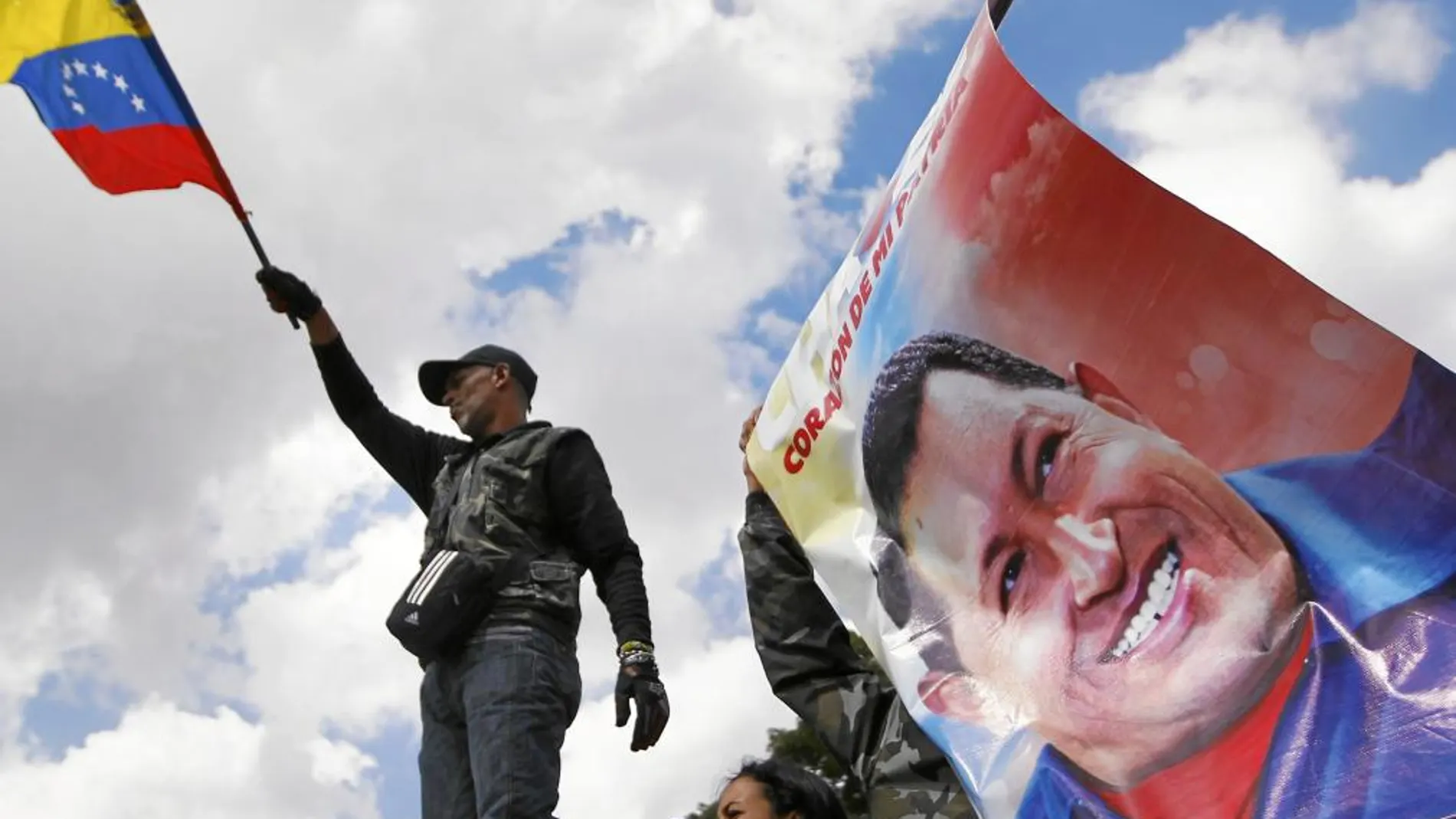 Un seguidor de Chávez ondea una bandera de Venezuela frente al hospital militar de Caracas en el que está ingresado