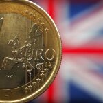 Una moneda de 1 euro ante una bandera de Reino Unido