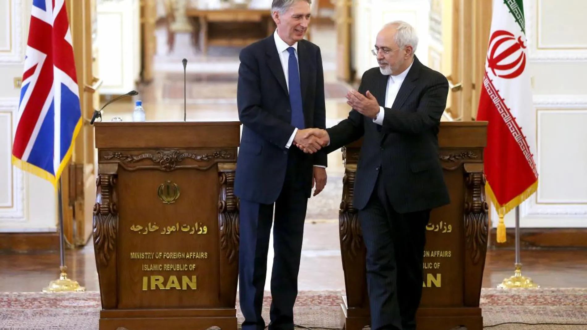 El ministro de Exteriores iraní, Mohammad Javad Zarif, saluda a su homólogo británico, Philip Hammond