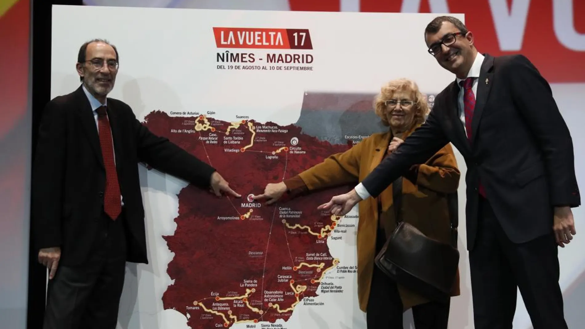 El director general de la Vuelta Ciclista a España, Javier Guillén (d), la alcaldesa de Madrid, Manuela Carmena (2d), y el director general de Deportes del Ayuntamiento, Javier Odriozola (i), señalan las etapas madrileñas en el mapa