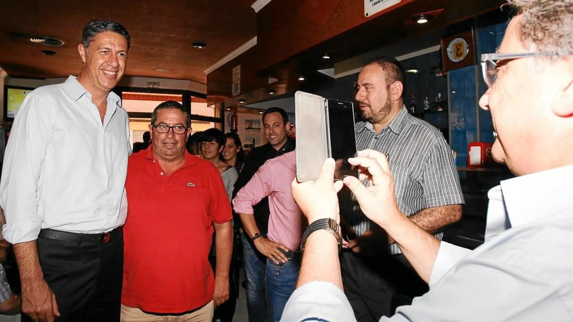El candidato por Girona, Enric Millo, toma una fotografía de Albiol con un simpatizante, ayer en Roses (Girona)