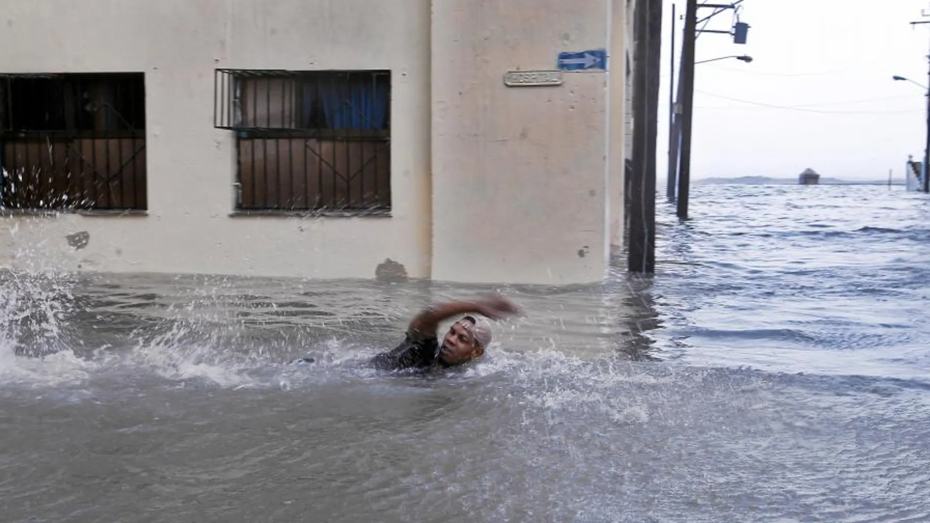 Un hombre nada por una calle inundada de La Habana, Cuba, donde el huracán dejó varios muertos
