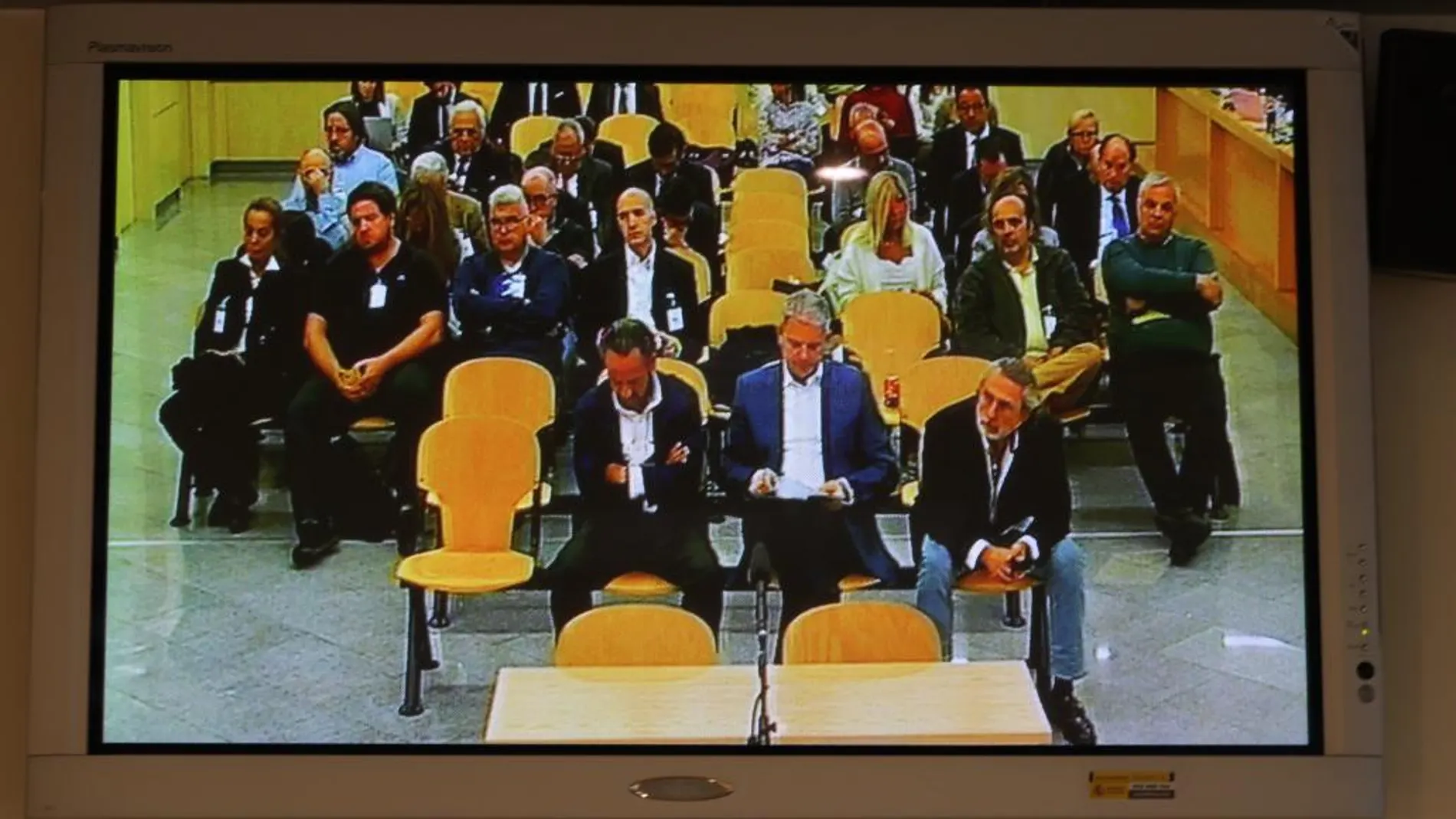 Los acusados vistos desde un monitor de la sala de prensa de la Audiencia Nacional / Efe