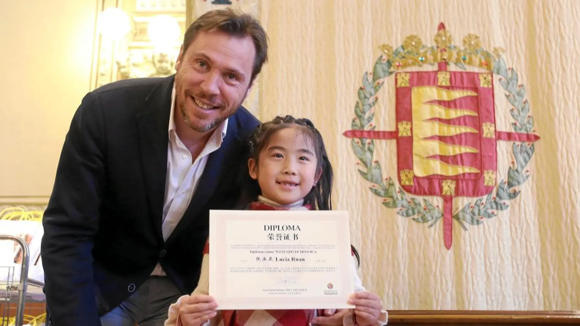 El alcalde de Valladolid, Óscar Puente, se fotografía con una joven participante china, que muestra con orgullo el diploma de invitada de honor que le entregaron en el Ayuntamiento