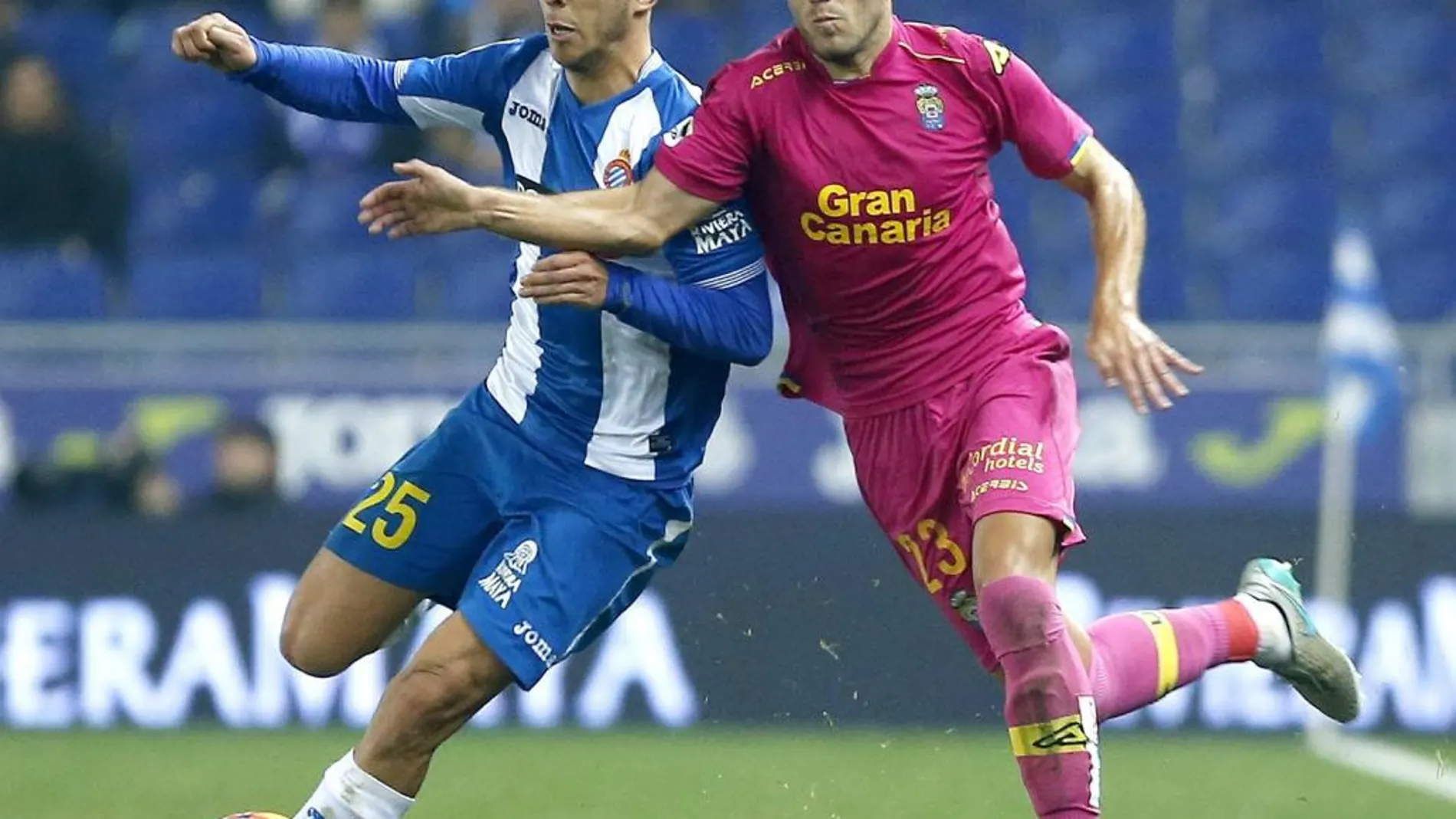 El centrocampista del Espanyol Marcos Asensio, pelea un balón con el centrocampista de la UD Las Palmas Javi Castellano