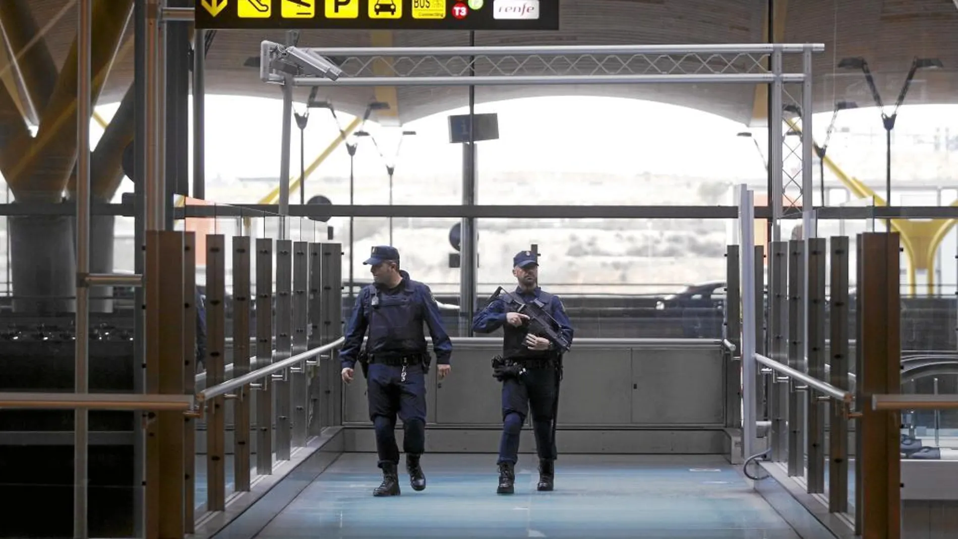 Dos policías vigilan, ayer, el madrileño aeropuerto Adolfo Suárez tras los atentados de Bruselas