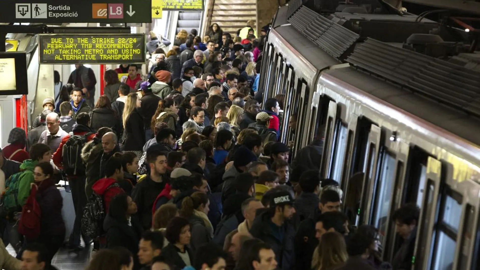 Usuarios del Metro de Barcelona esperan en el andén de la estación de Plaza España la llegada de un convoy durante los servicios mínimos decretados en la jornada de huelga de Metro