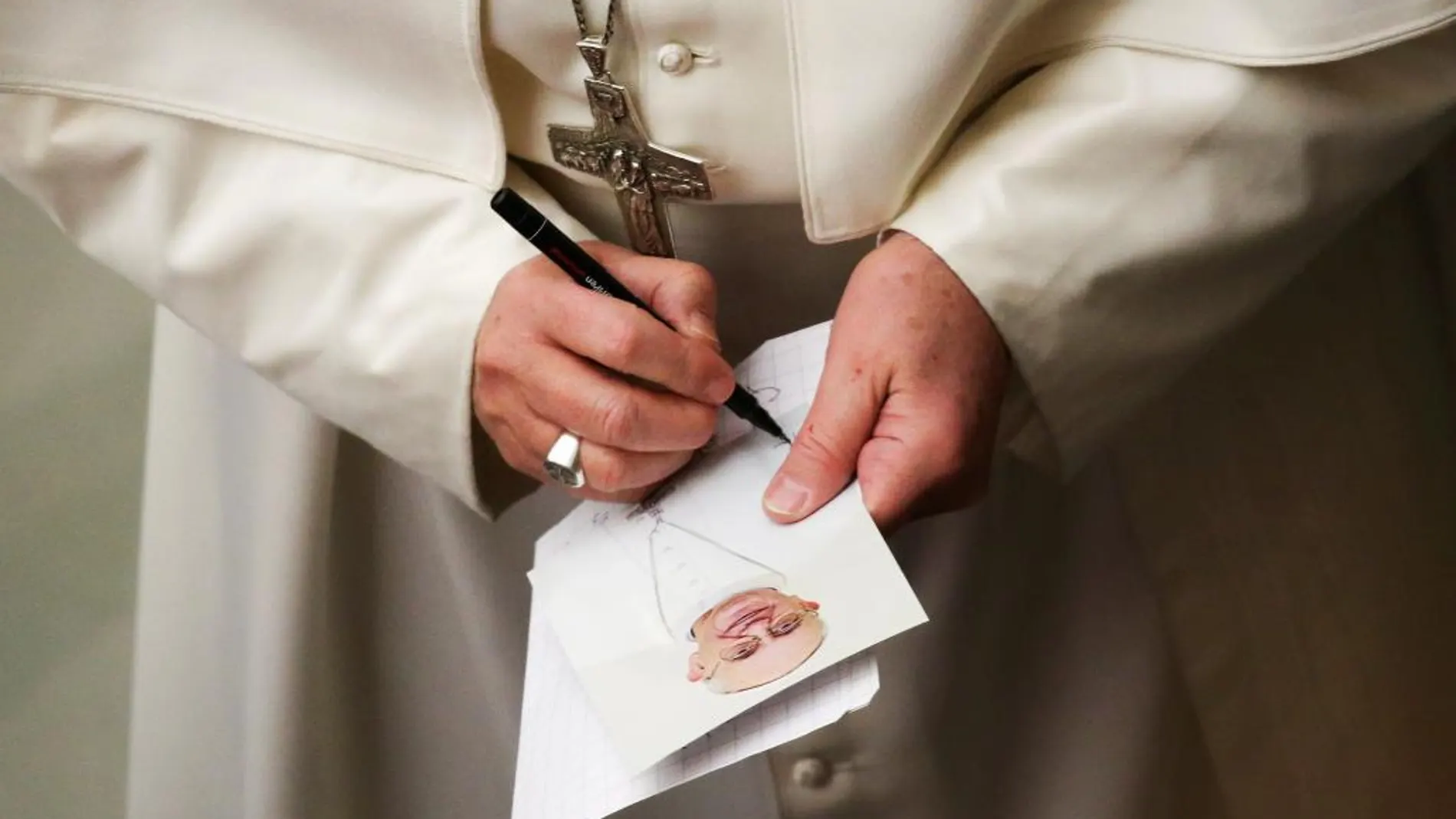 El Papa firma una imagen suya durante la audiencia