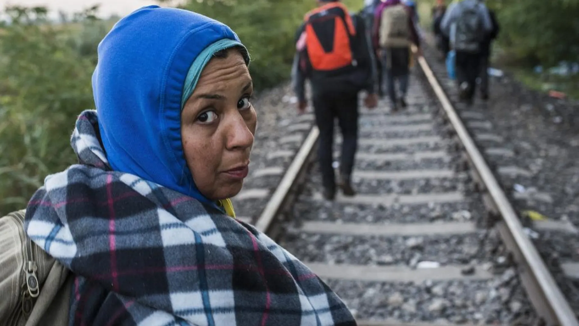 Una migrante procedente de Serbia camina por la vía del tren con dirección a la población fronteriza de Roszke, situada a unos 180 km al sureste de Budapest (Hungría).