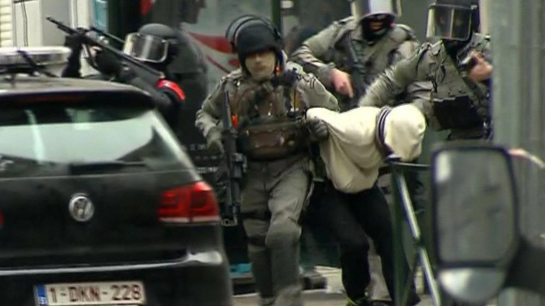 Oficiales de policía escoltan a un detenido en Molenbeek