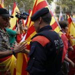Un mosso saluda a una de las personas que participó en la marcha del Día de la Hispanidad en Barcelona/ Ap