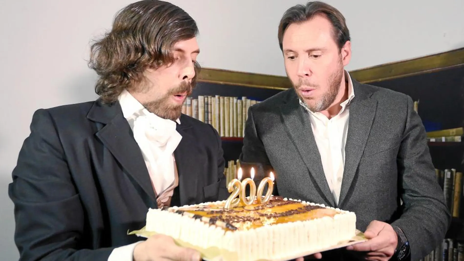 El alcalde de Valladolid, Óscar Puente, sopla las velas de una tarta junto a un actor caracterizado de José Zorrilla.