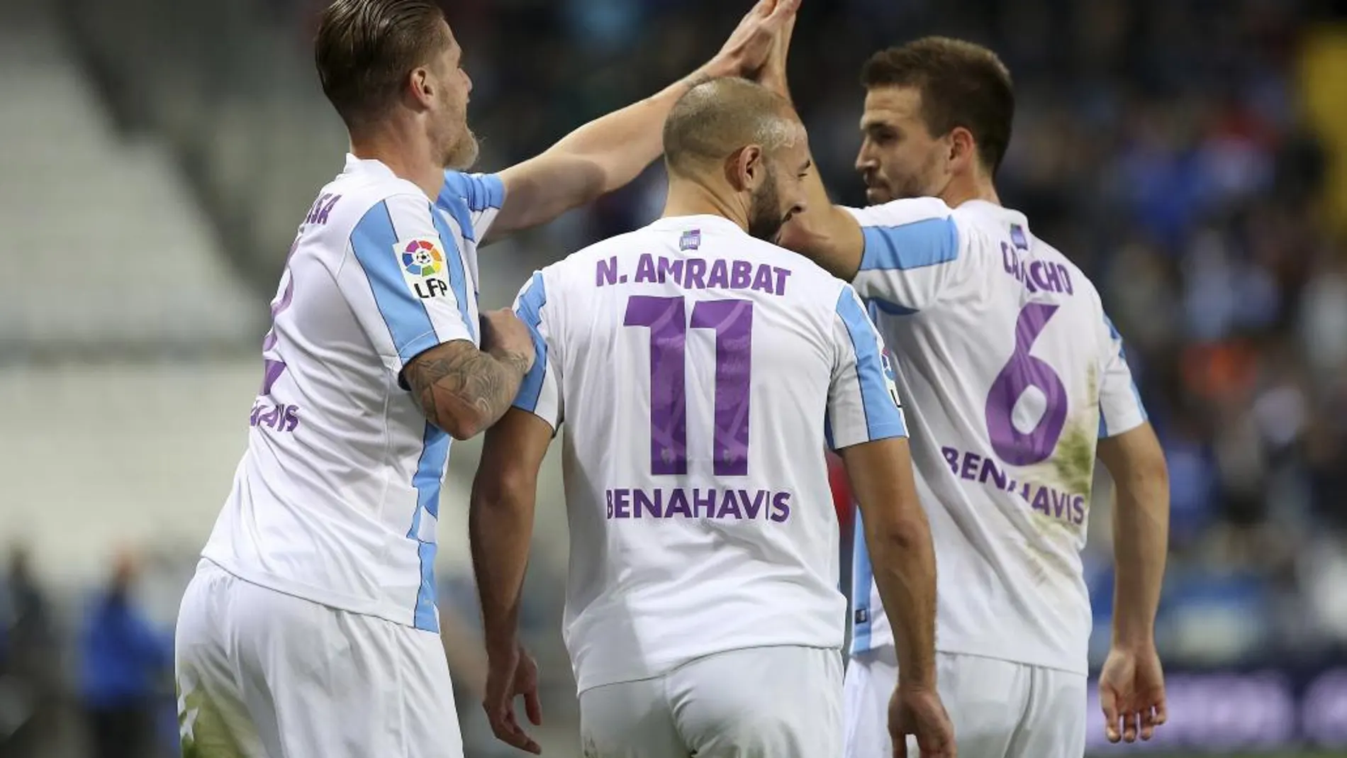 El defensa del Málaga CF. Raúl Albentosa (i) es felicitado por sus compañeros, Ignacio Camacho (d) y Nordin Amrabat (c), tras anotar el segundo gol del equipo