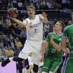 El base esloveno del Real Madrid Luka Doncic intenta avanzar con el balón ante el alero polaco del Unicaja Adam Waczynski