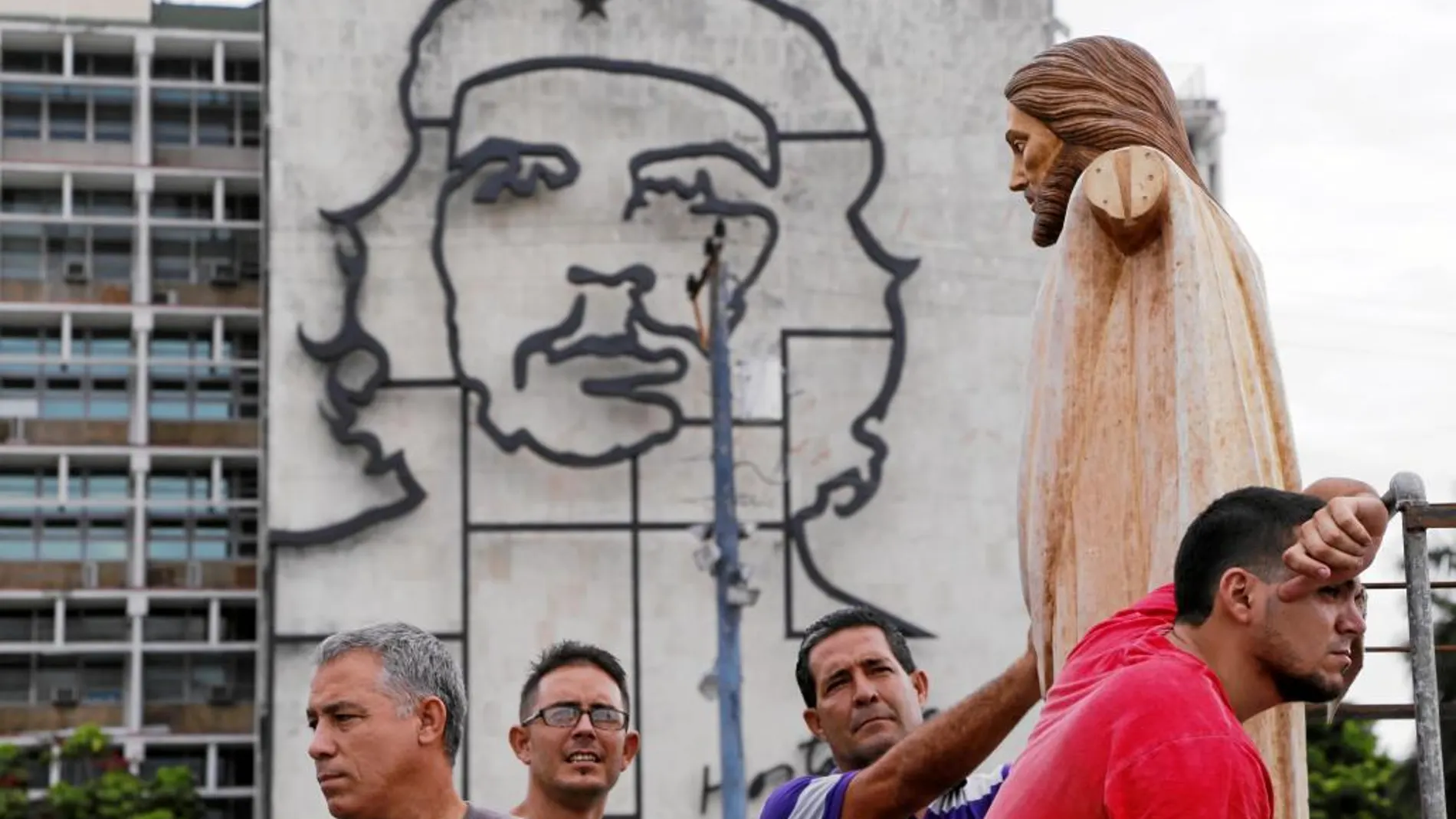 Unos trabajadores llevan la escultura de un Cristo a la Plaza de la Revolución, en La Habana, donde se celebrará un acto en la visita del Papa