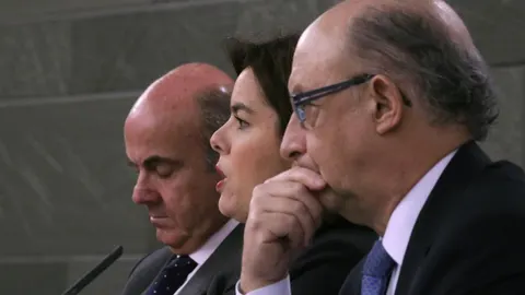 La vicepresidenta del Gobierno, Soraya Sáenz de Santamaría, acompañada por los ministros de Economía y Competitividad y de Hacienda, Luis de Guindos (i) y Cristóbal Montoro, respectivamente, durante la rueda de prensa posterior al Consejo de Ministros
