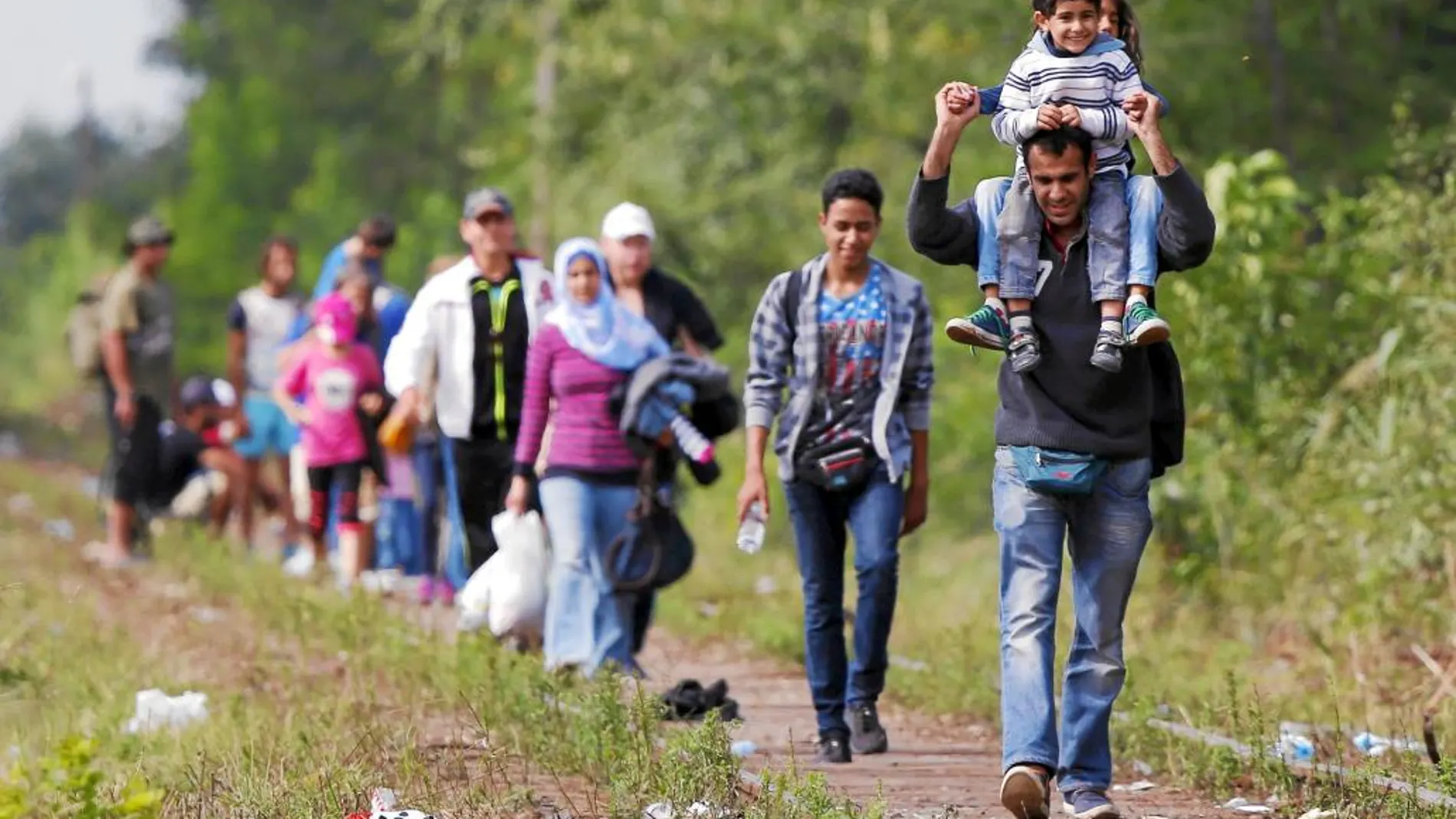 Migrantes sirios siguen la vía del tren después de cruzar la frontera entre Serbia y Hungría por la localidad de Roskze