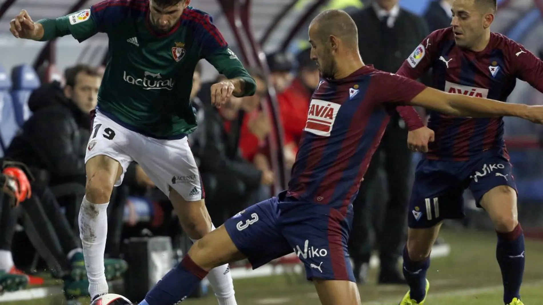 El defensa del Eibar, Juncá, lucha un balón con Kenan, delantero del Osasuna