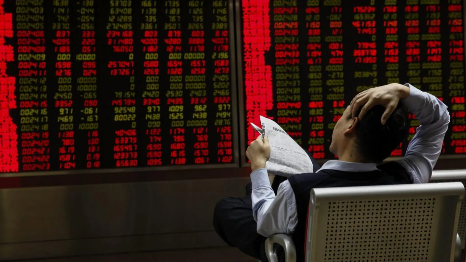 Inversores observan la información bursátil en una correduría en Pekín (China)