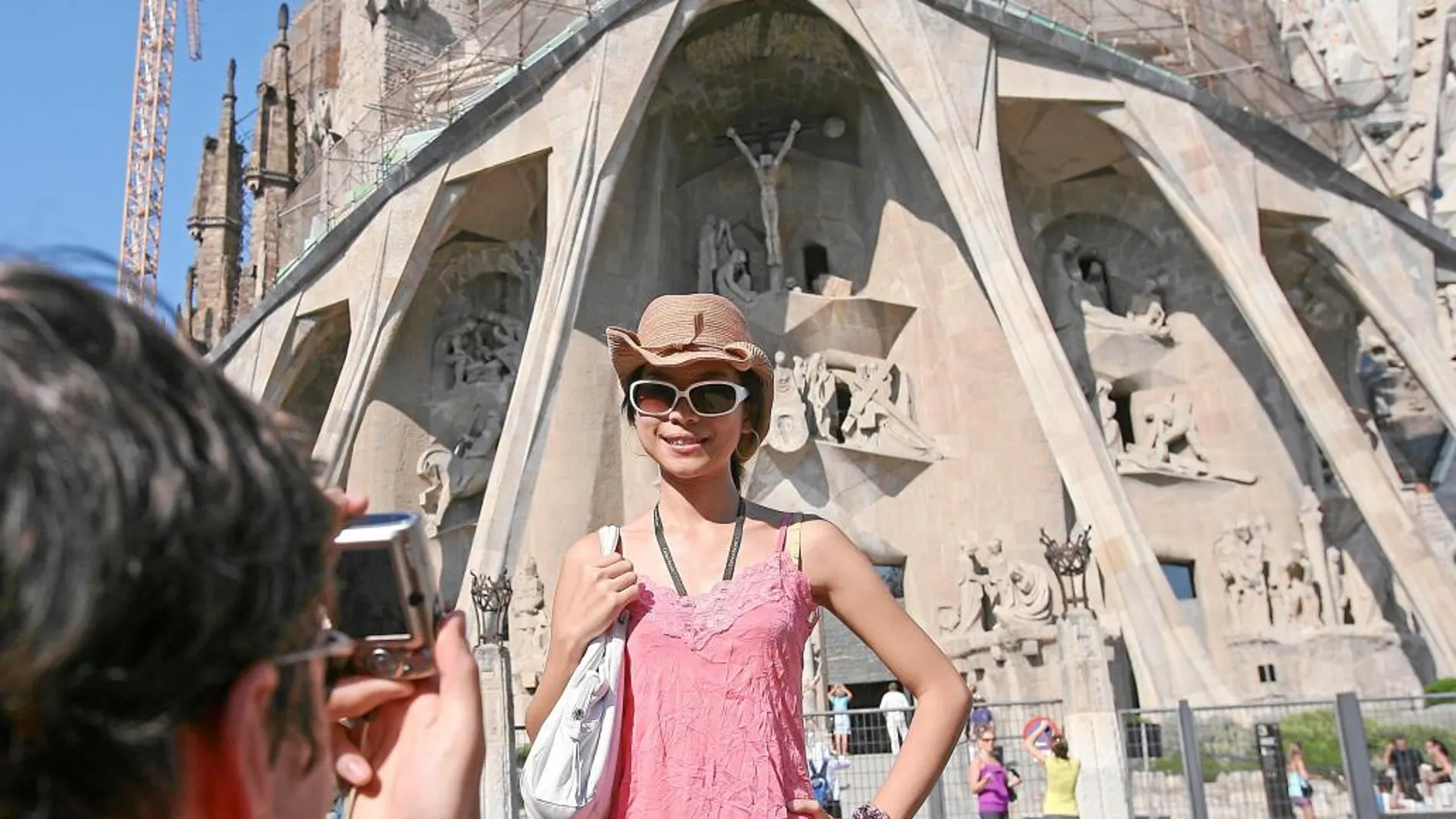 Turistas en Barcelona se hacen fotos frente a la Sagrada Familia