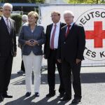 La canciller alemana, Angela Merkel (2i), el jefe del Gobierno del estado de Sajonia, el cristianodemócrata Stanislaw Tillich (i), el presidente de la Cruz Roja alemana, Rudolf Seiters, y el alcalde de Heidenau, Jürgen Optiz (2d), durante su visita al centro de refugiados objeto de violencia por parte de grupos neonazis
