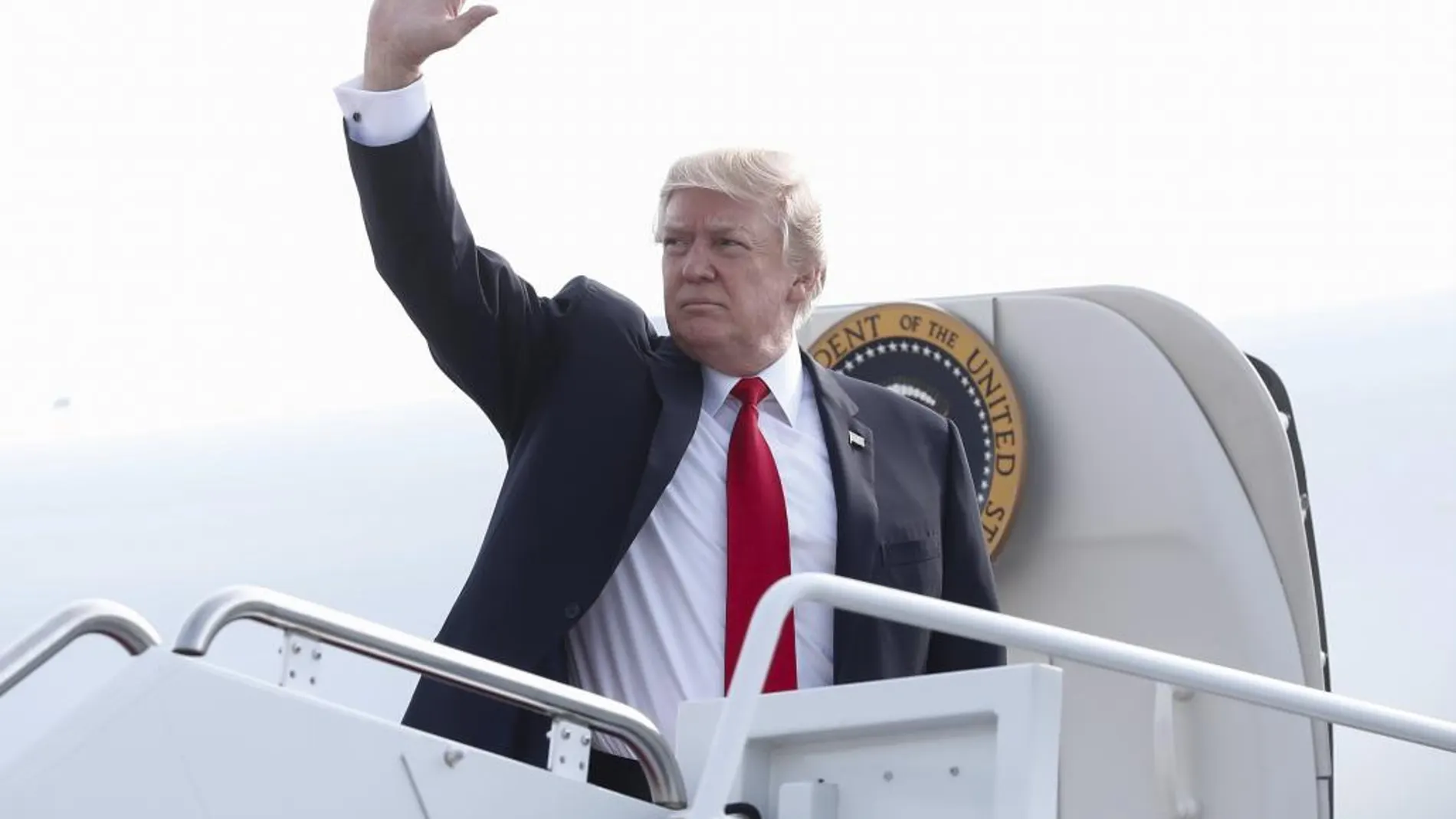 Donald Trump saluda a bordo del Air Force One, hoy sábado, en la base aérea de Andrews.