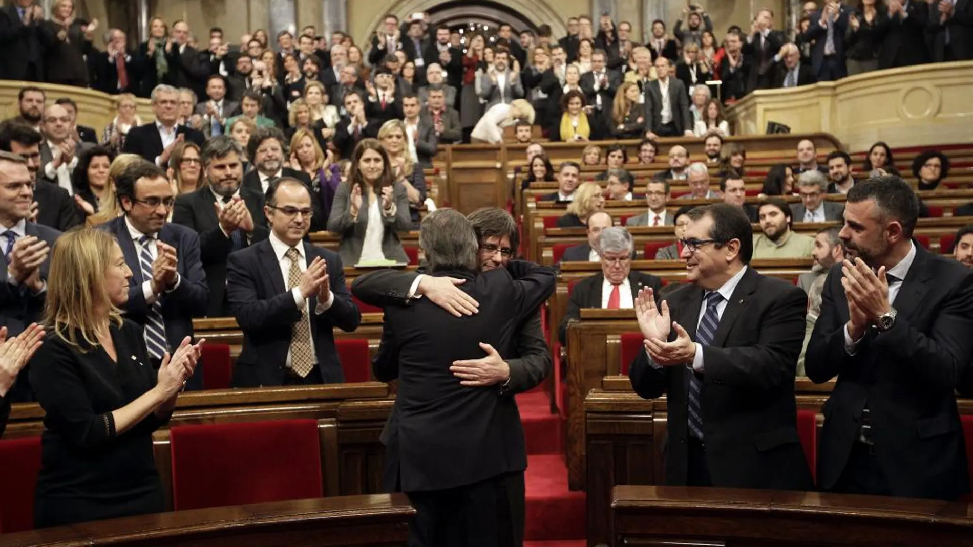 El expresidente Artur Mas abraza a Carles Puigdemont a la finalización del pleno de investidura.