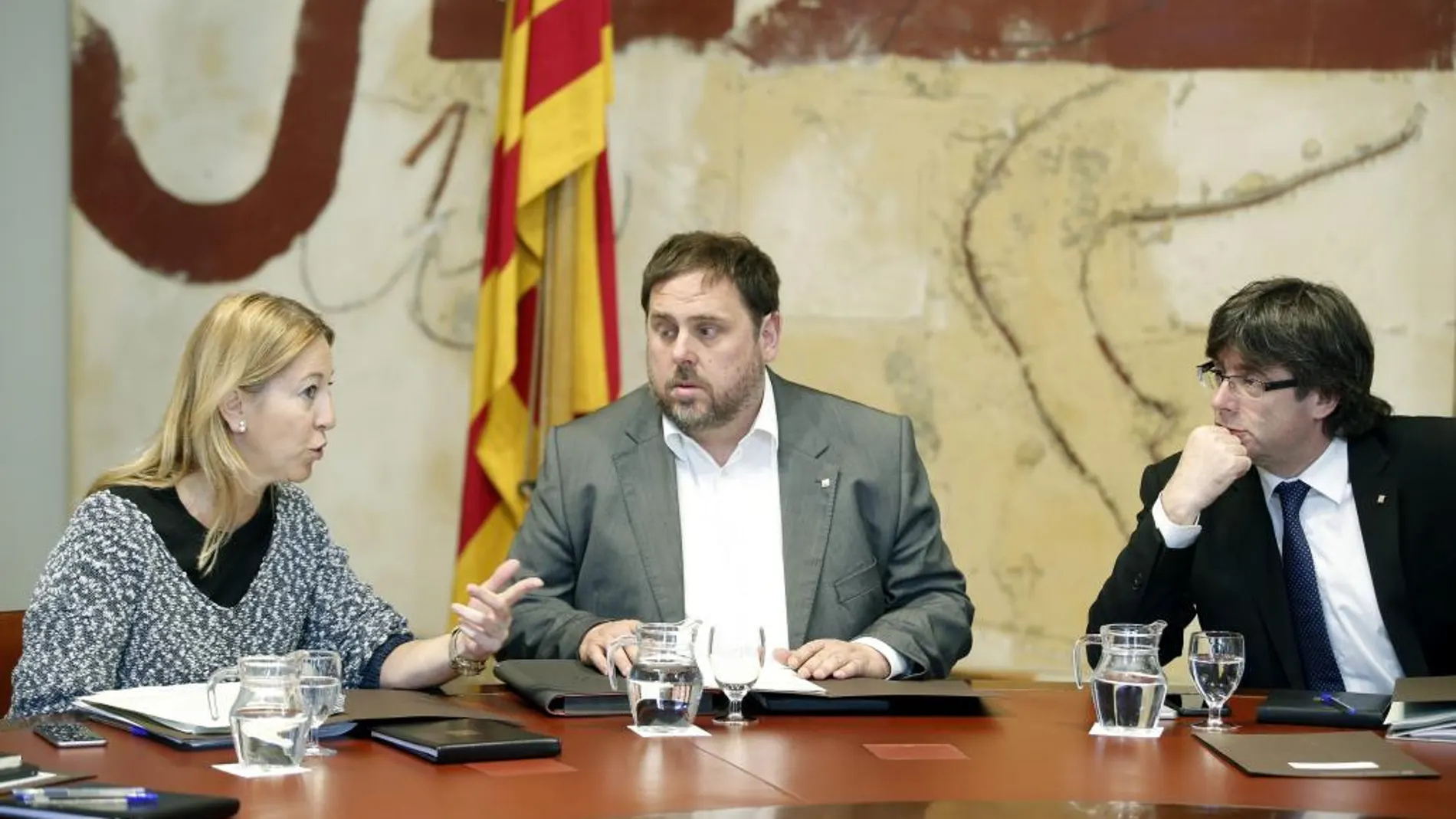 El presidente de la Generalitat, Carles Puigdemont, conversa con el vicepresidente y conseller de Economia Oriol Junqueras (c) y la portavoz de la presidencia Neus Munté