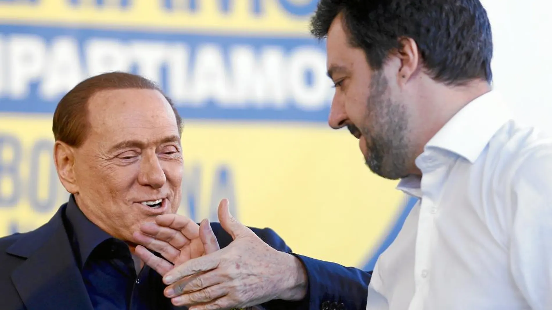 Berlusconi estrecha la mano ayer al jóven líder de la Liga Norte, Matteo Salvini, en Bolonia