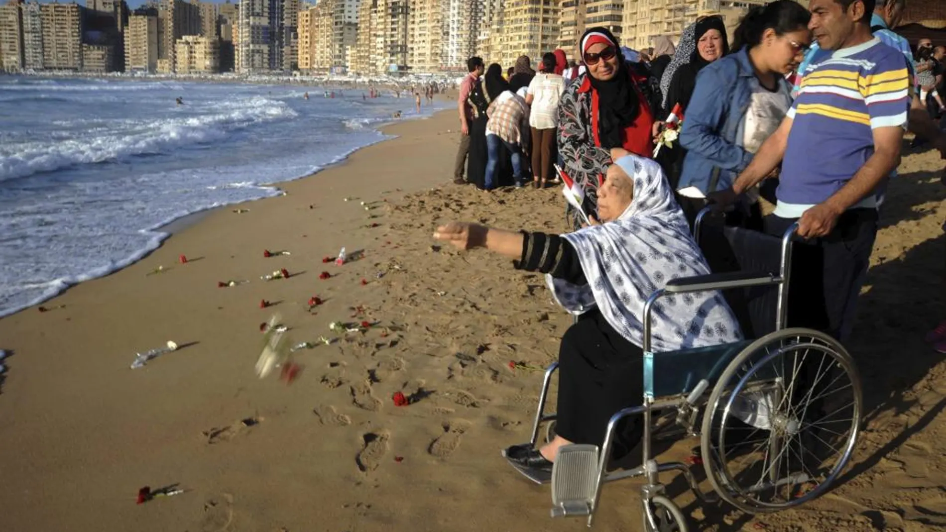 Un grupo de personas lanza flores al mar durante un homenaje a las víctimas del avión de Egyptair en Alejandría