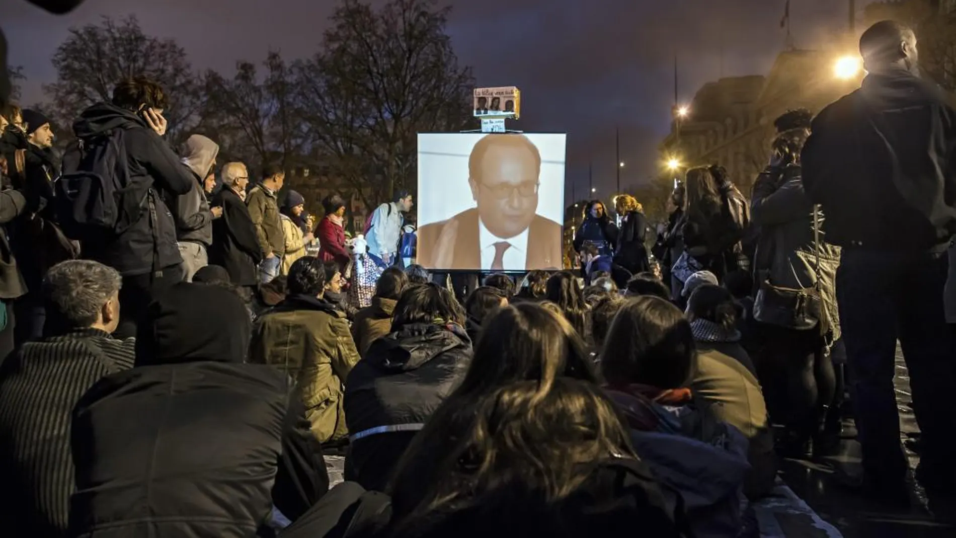 Integrantes del movimiento nacido en redes sociales "La Nuit Debout"observan una intervención del presidente François Hollande