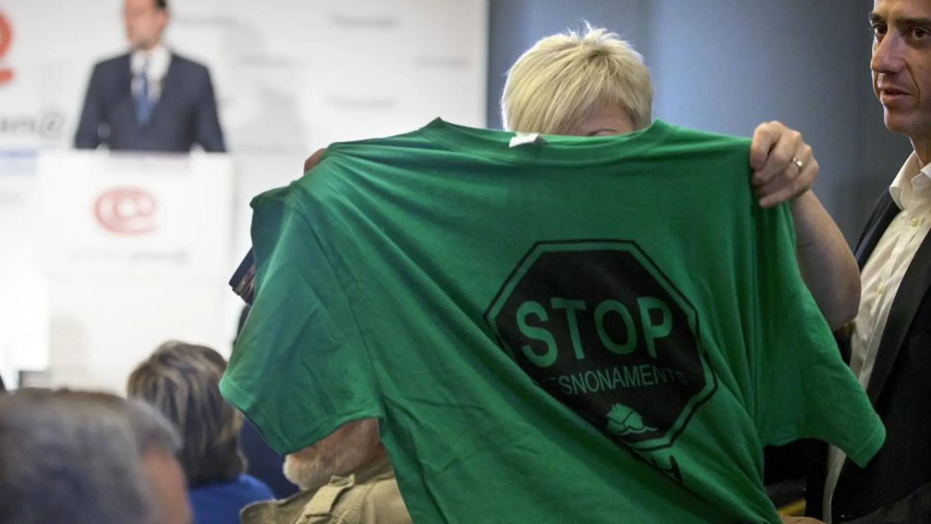 Una activista de la PAH muestra una camiseta alusiva a los deshaucios durante la intervención de Rajoy