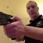 Un agente de policía norteamericano haciendo una demostración de una pistola eléctrica tipo táser